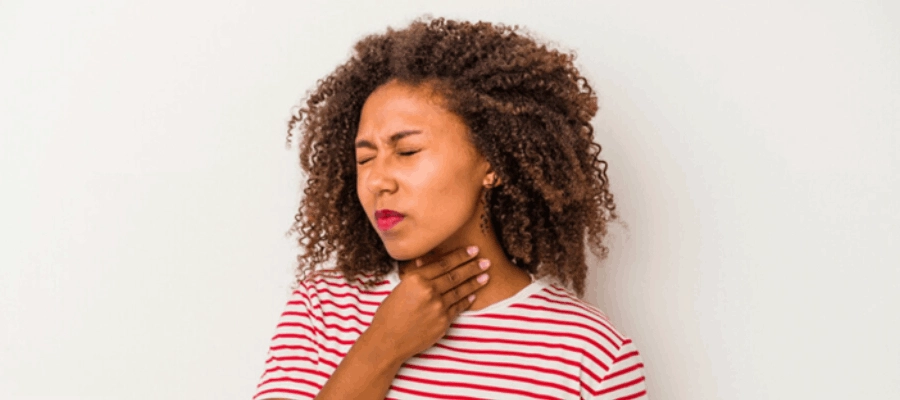 mulher jovem com catarro preso na garganta colocando a mão no pescoço