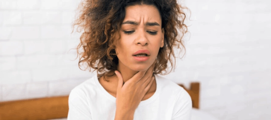 mulher jovem com faringoamigdalite reclamando de dor de garganta