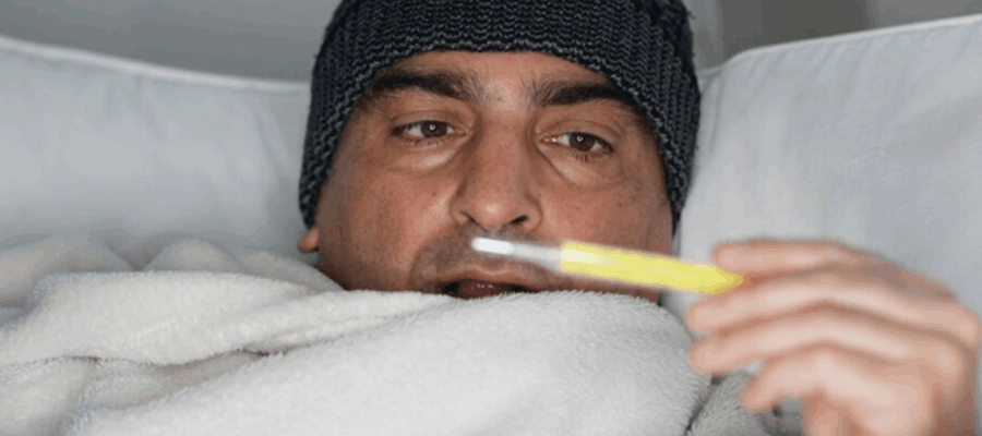 homem com termômetro em dúvida se pode estar com pneumonia sem febre.