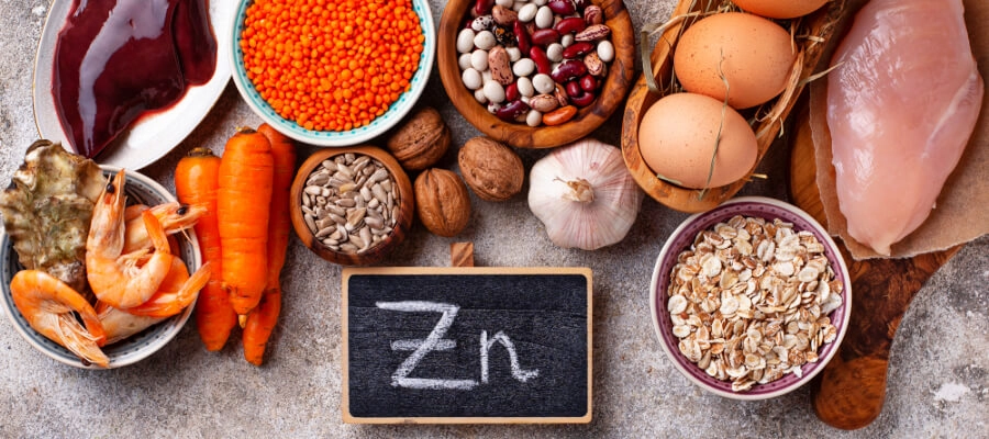 alimentos ricos em zinco sobre a mesa, incluindo ovos, lentilhas, semente-de-abóbora e frutos-do-mar 