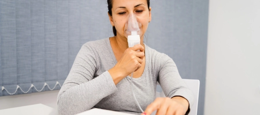 Mulher faz nebulização caseira e utiliza máscara respiratória.