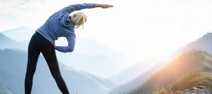 uma mulher fazendo ioga nas montanhas
