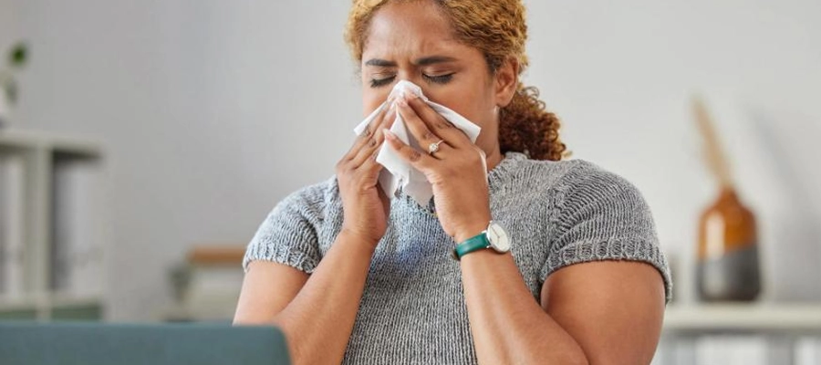 mulher sofrendo de congestão nasal assoando o nariz