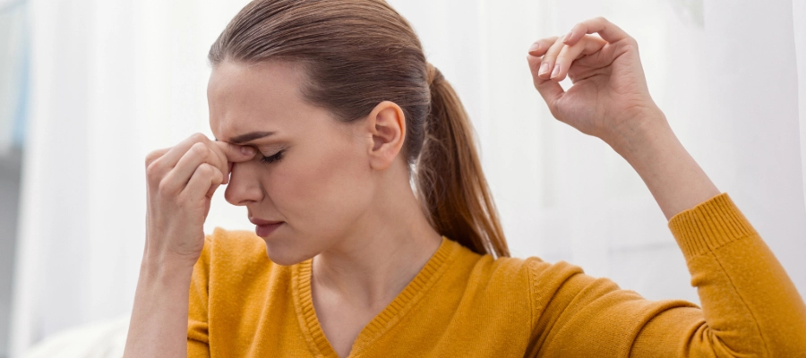 Mulher com dor facial, sintoma típico de quem busca como acabar com a sinusite rápido.