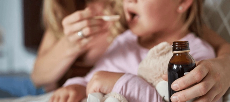 mulher oferecendo uma colher de xarope para tosse para sua filha