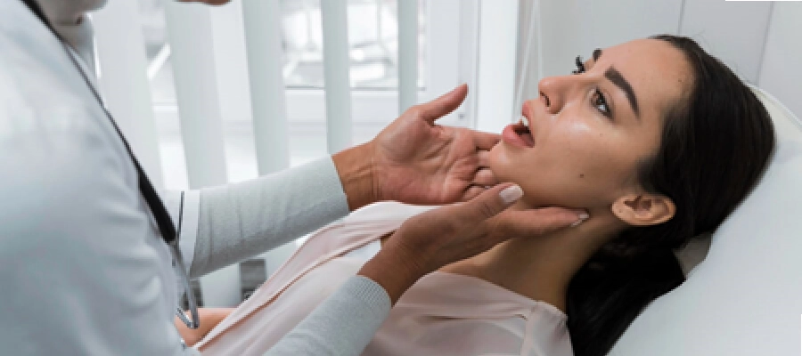 médico observando a garganta de uma paciente com suspeita de faringite bacteriana. 