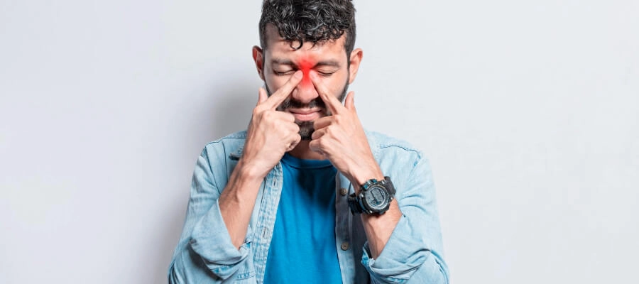 homem com as pontas do dedo indicador massagendo o nariz indicando desconforto nasal