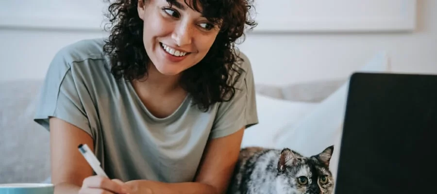 uma mulher sentada em uma cama com um gato