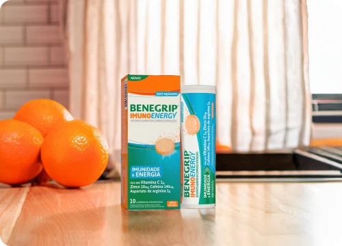 Imagem de Benegrip Imuno em cima de uma mesa com laranjas no fundo.